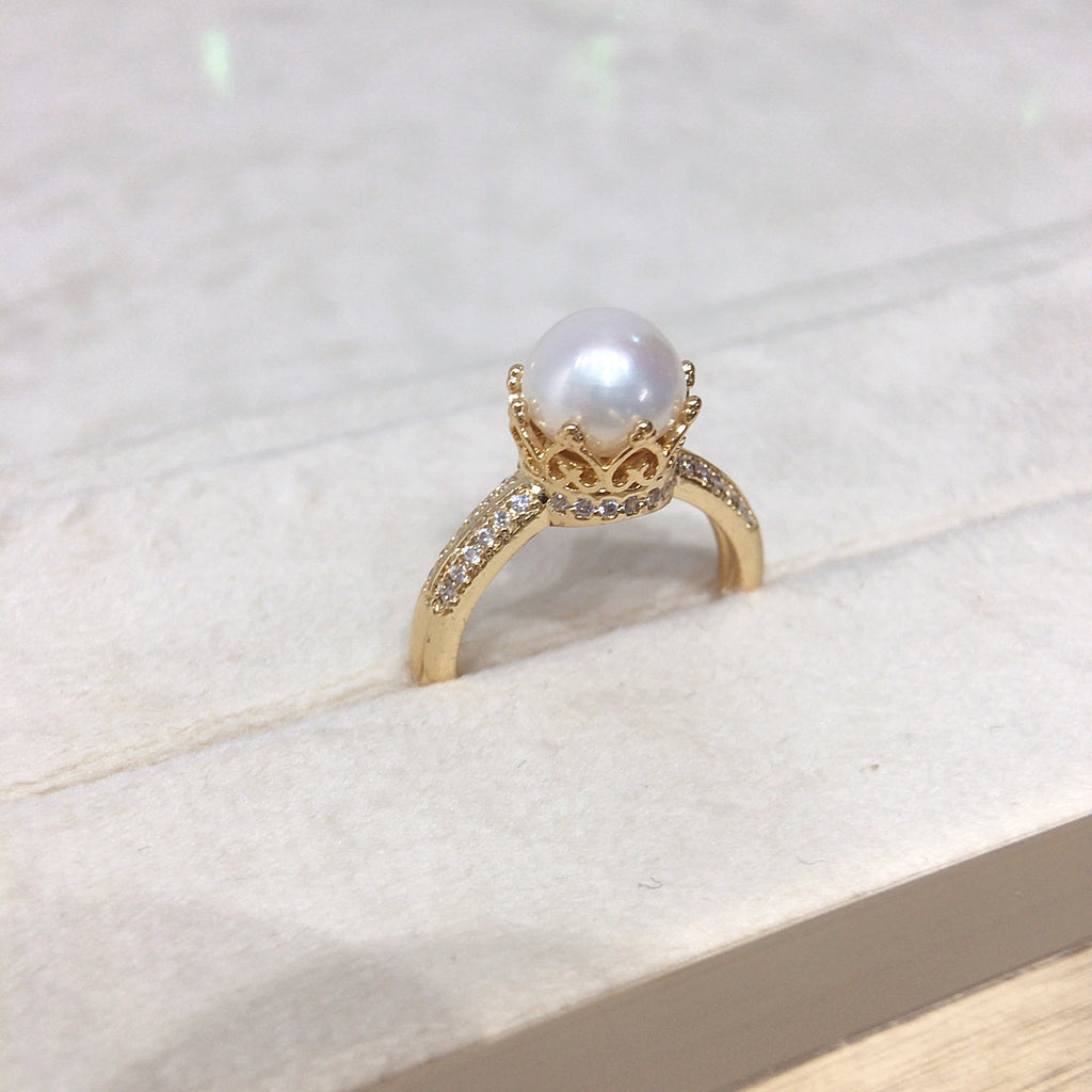 18k gold ring center pearl, rounded in diamonds