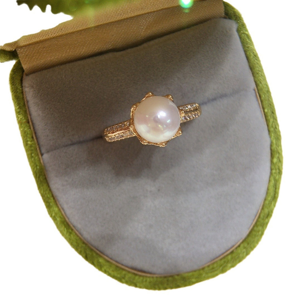 18k gold ring center pearl, rounded in diamonds