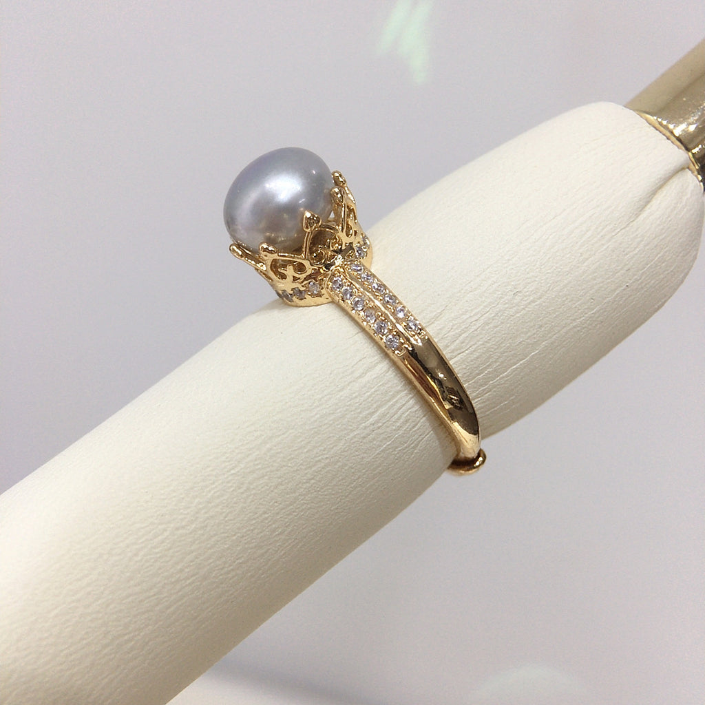 18k gold ring center pearl, rounded in diamonds