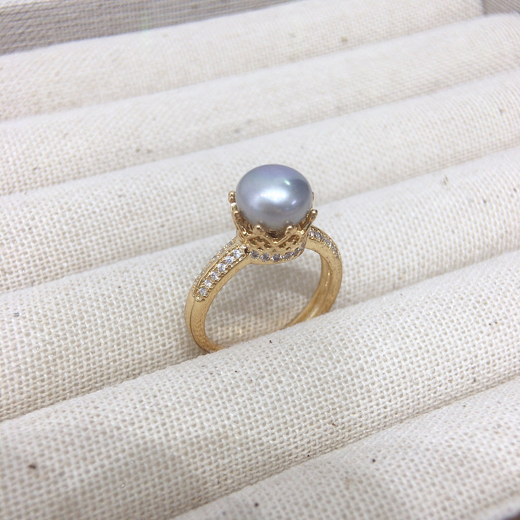 18k gold ring center pearl, rounded in diamonds