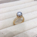 18k gold ring center pearl, rounded in diamonds